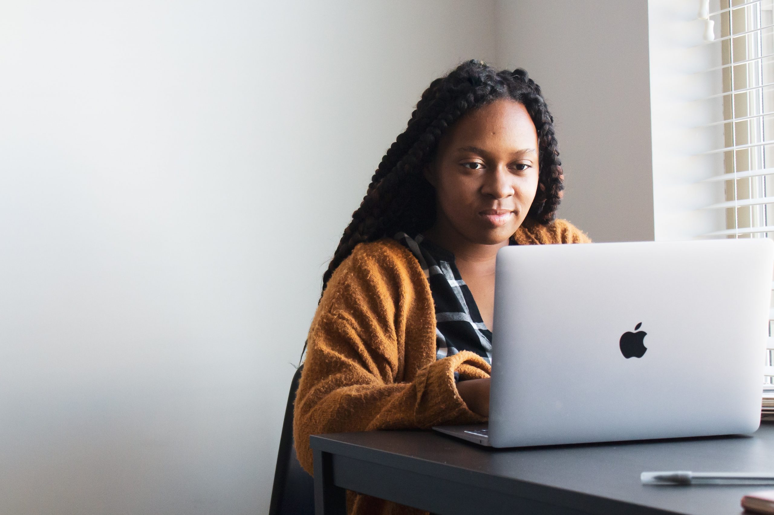 A female university graduate working at a laptop