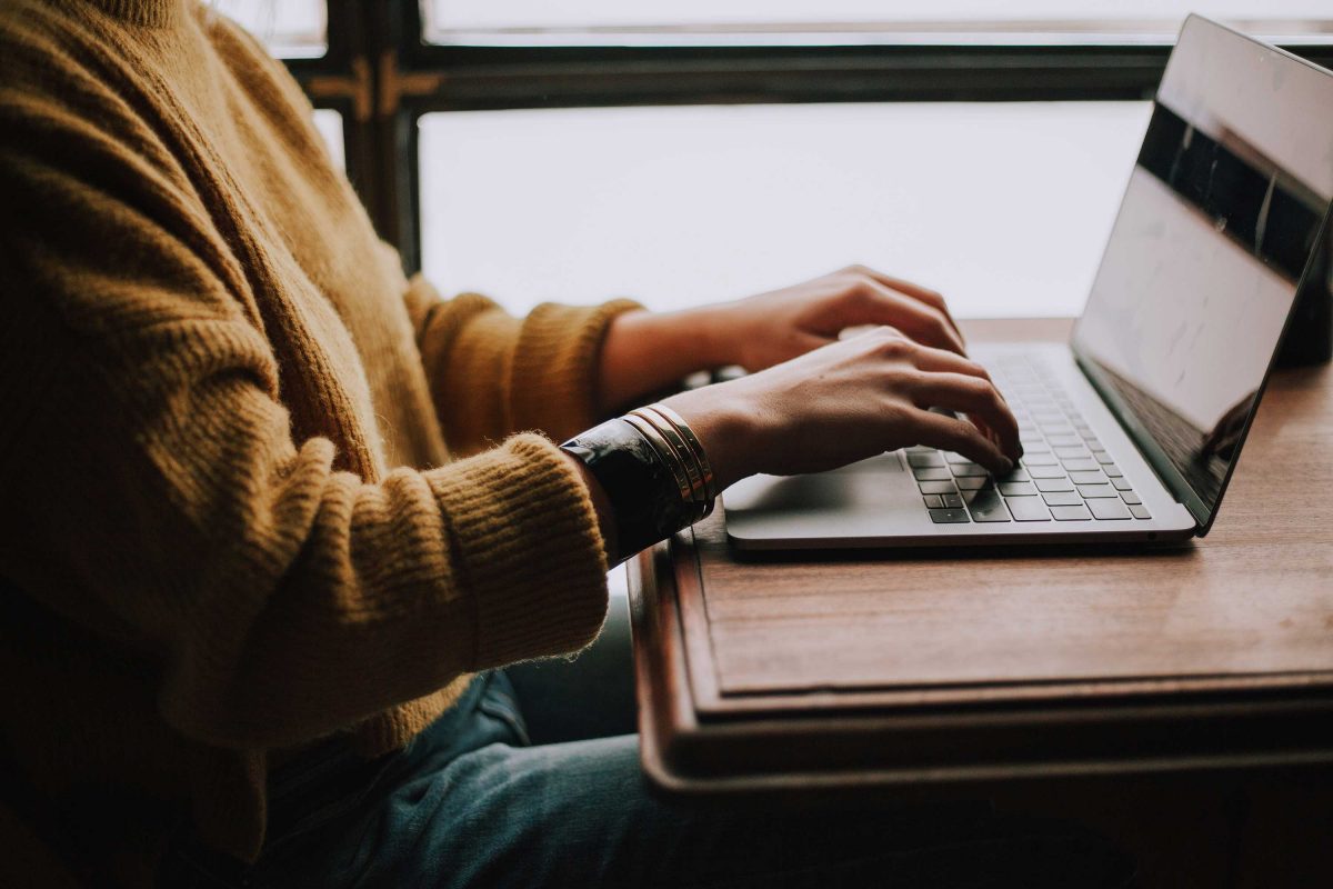 A person types on a laptop