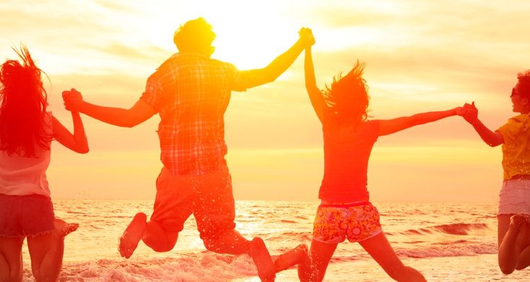 Four friends jumping on the beach