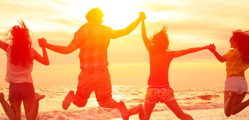 Four friends jumping on the beach