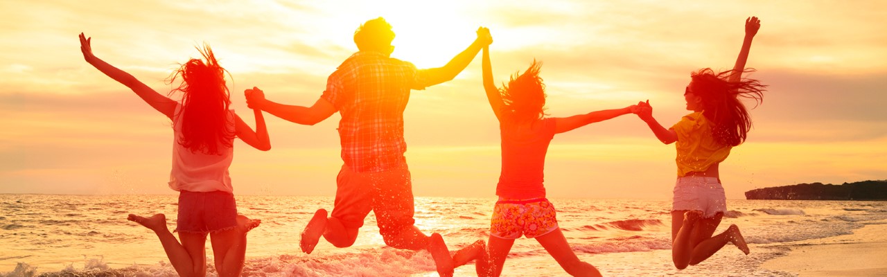 Four friends jumping on the beach