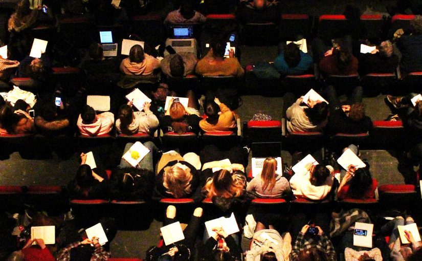 Birdseye view image of students making notes at the conference