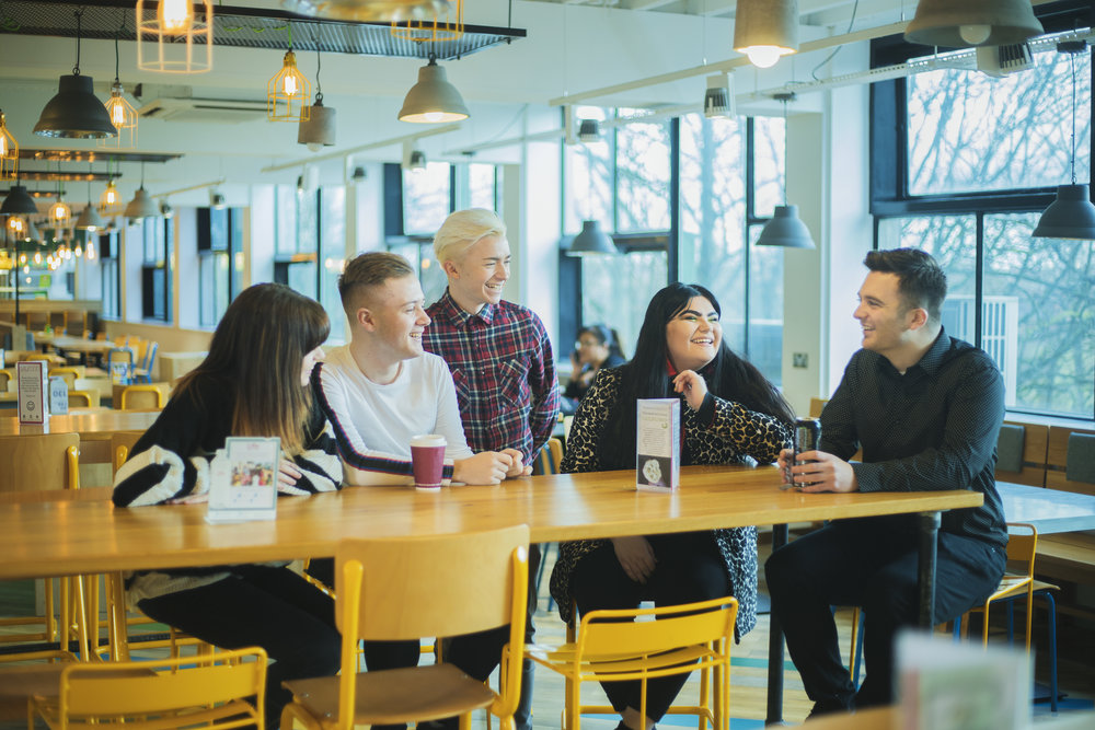 image: recent graduate ryan giving advice to students sitting on a table