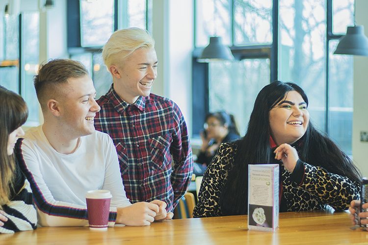 Image; group of student social media assistants sat together in Maxwell cafe.