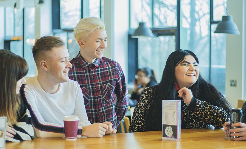 Image; group of student social media assistants sat together in Maxwell cafe.