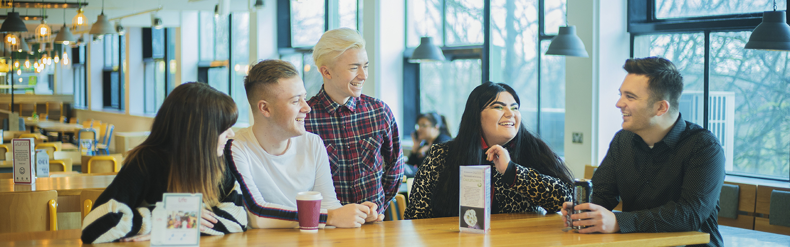 Image; group of student social media assistants sat together in Maxwell cafe.