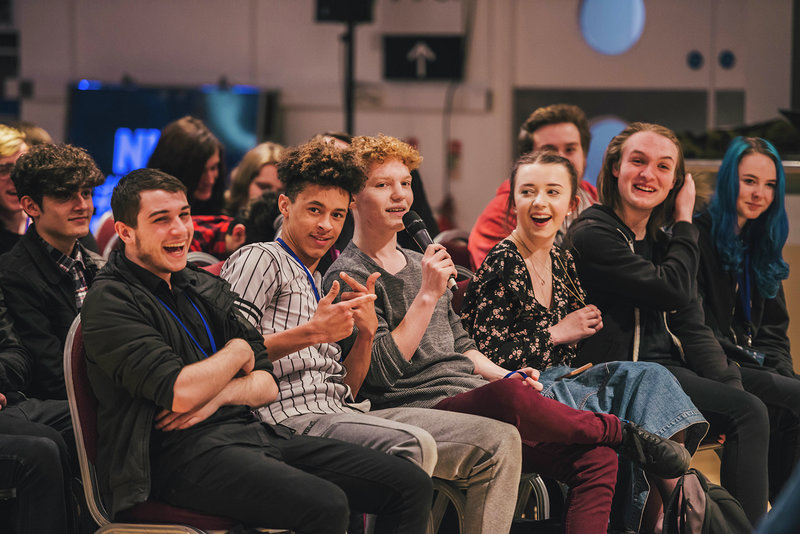 Image: School pupils answering question at conference with microphone