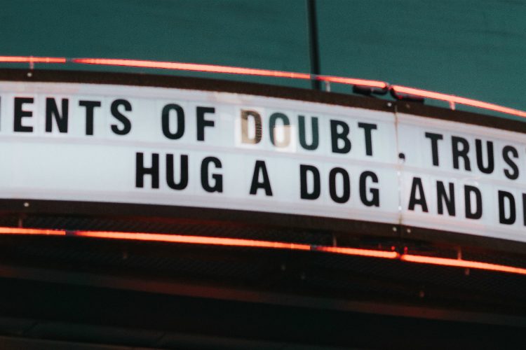 Old fashioned theatre sign reading: In moments of doubt, trust your gut, hug a dog and drink gin