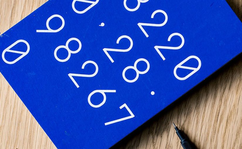 An up close shot of a laptop and a blue notebook