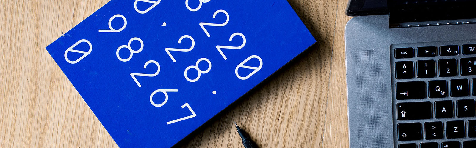 An up close shot of a laptop and a blue notebook