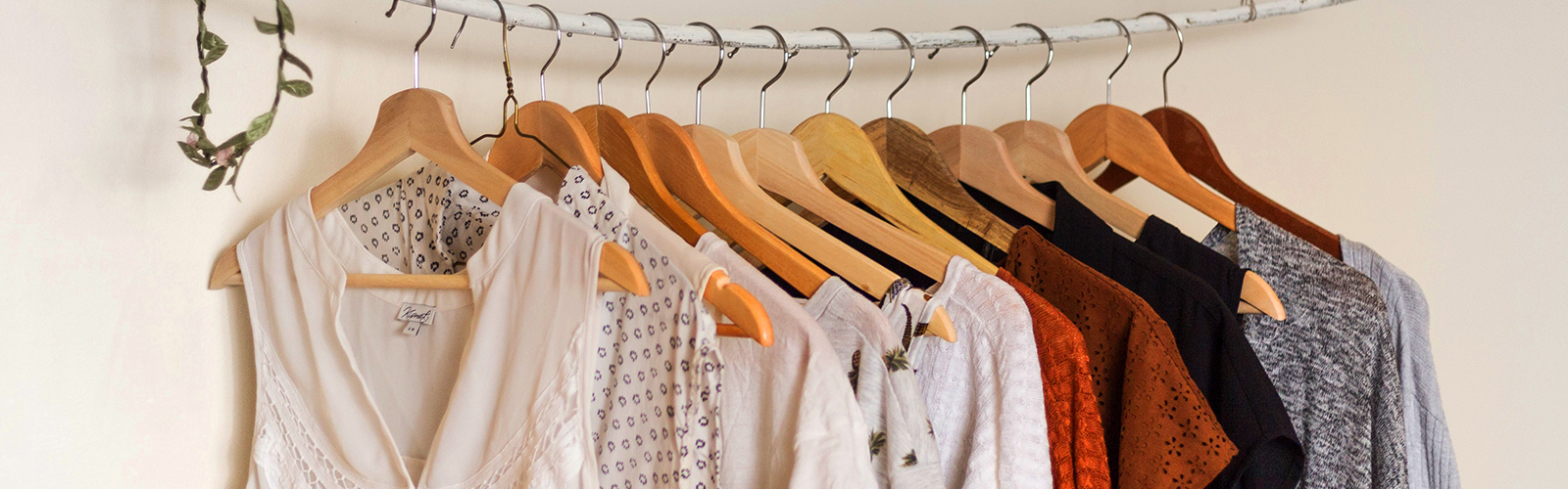 Several pieces of clothing are hung with clothes hangers on a rail