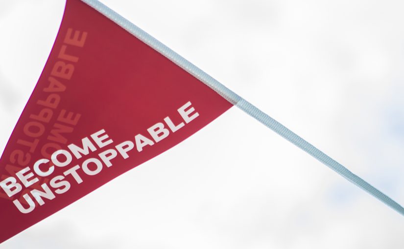 Become Unstoppable written on a red flag blowing in the wind