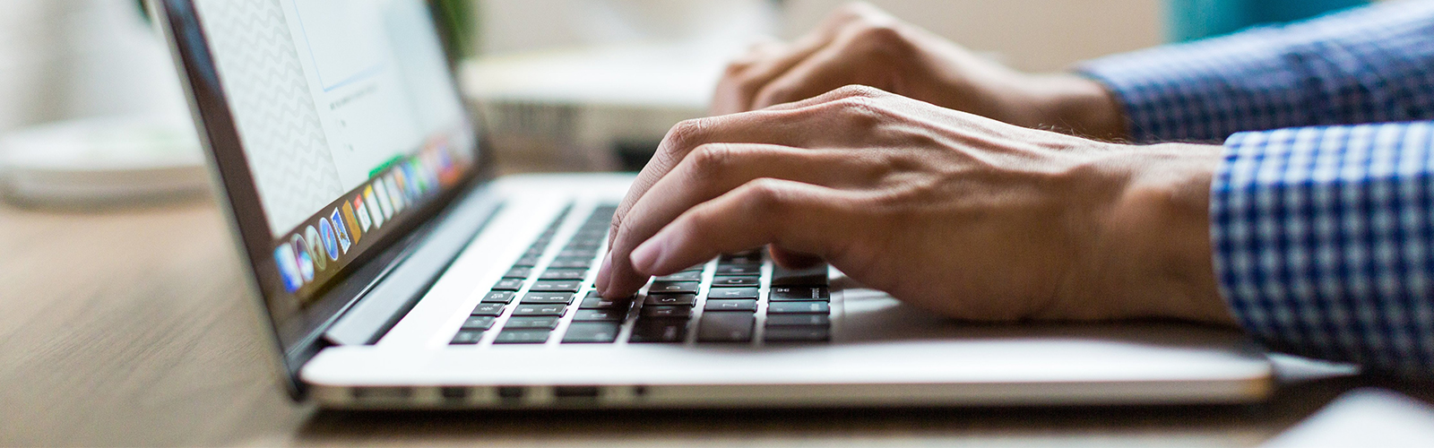 Photo of a person typing on the laptop