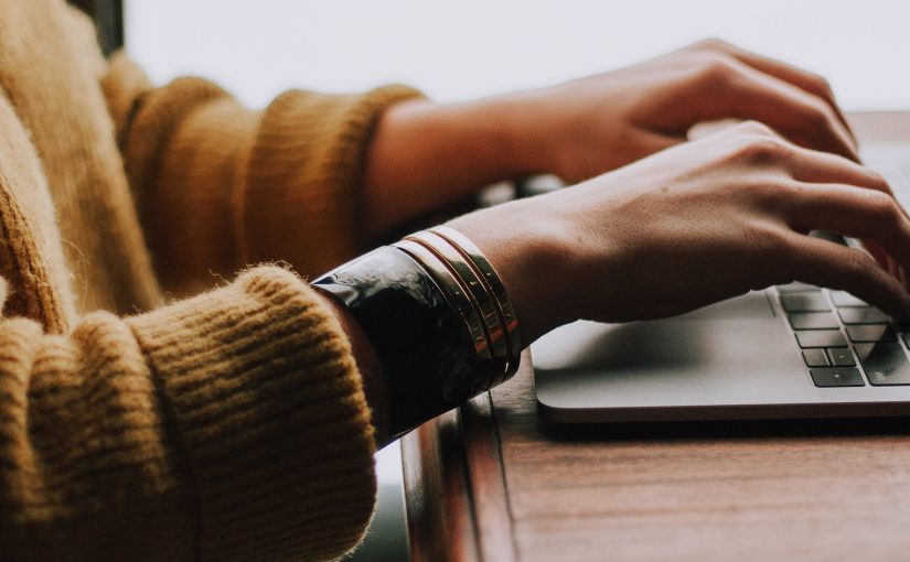 Photo of person's hand typing in her laptop