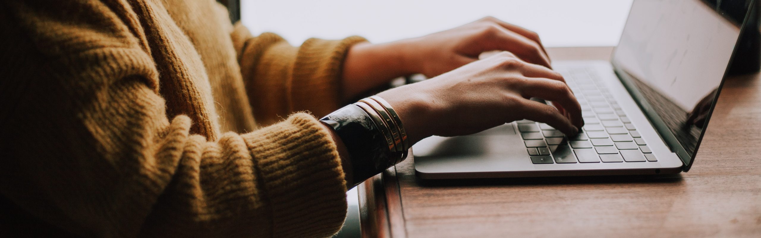 Photo of person's hand typing in her laptop