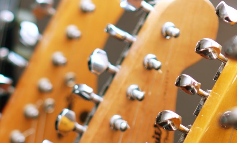 Image of the headstock and tuning pegs of several guitars