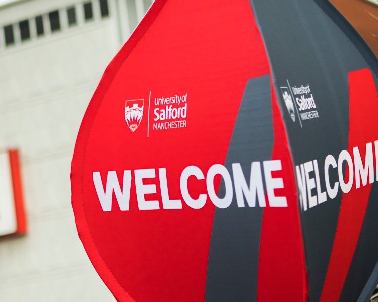 Photo of Uni of Salford welcome Balloon sign with university of Salford sign in the background blurred