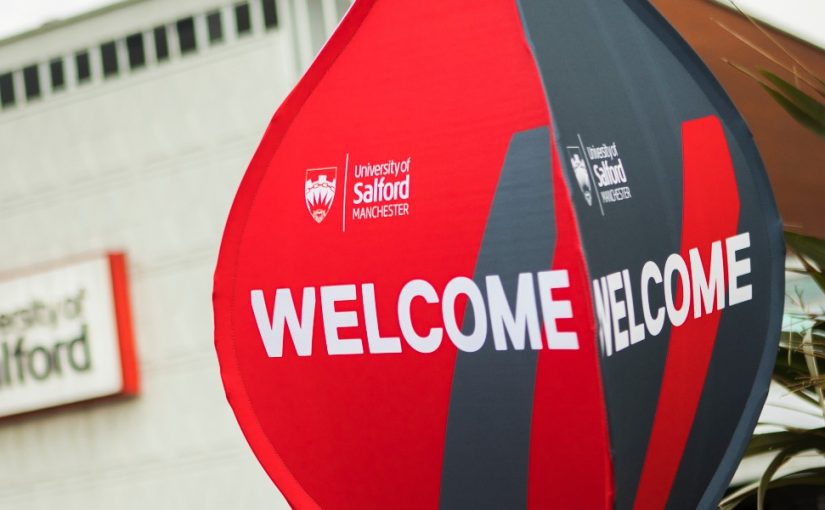 Photo of Uni of Salford welcome Balloon sign with university of Salford sign in the background blurred