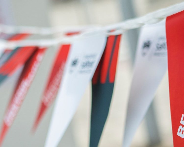 'Become Unstoppable' written on red, white and grey flags