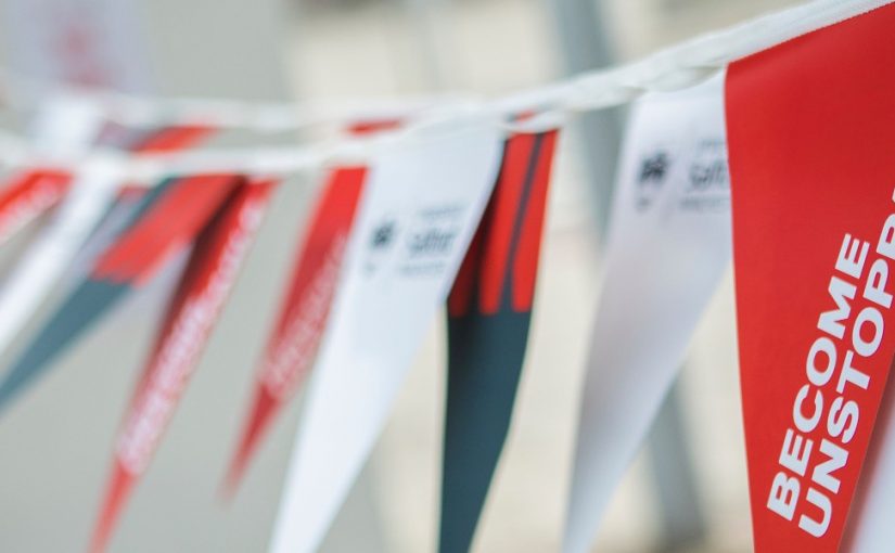 'Become Unstoppable' written on red, white and grey flags