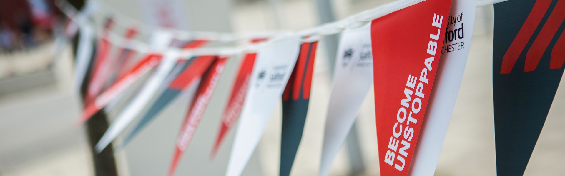 'Become Unstoppable' written on red, white and grey flags