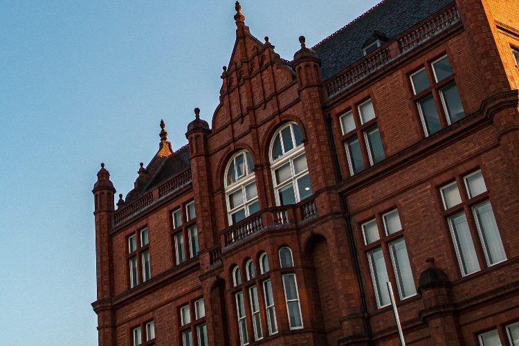 Photograph of the side of Peel Building against a bright blue sky