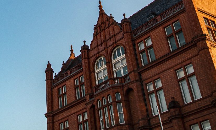 Photograph of the side of Peel Building against a bright blue sky