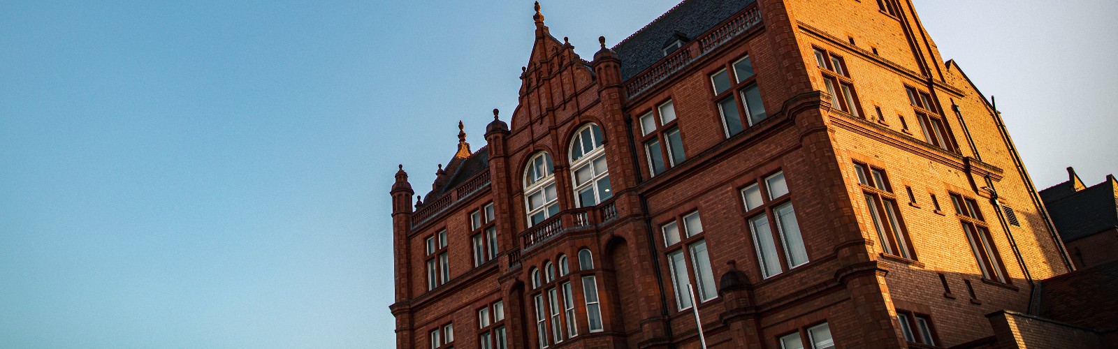 Photograph of the side of Peel Building against a bright blue sky