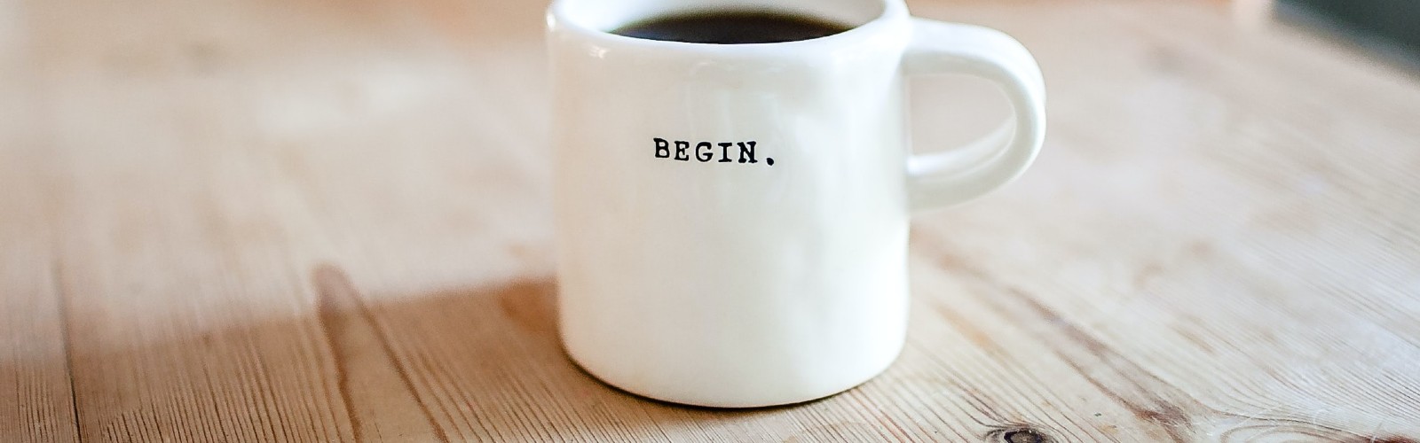 Image of a coffee mug with the word "begin" printed on it