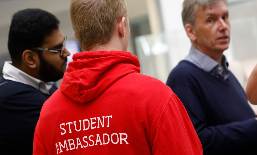 Photo from the back with the volunteer wearing the salford uni student red student ambassdor hoodie