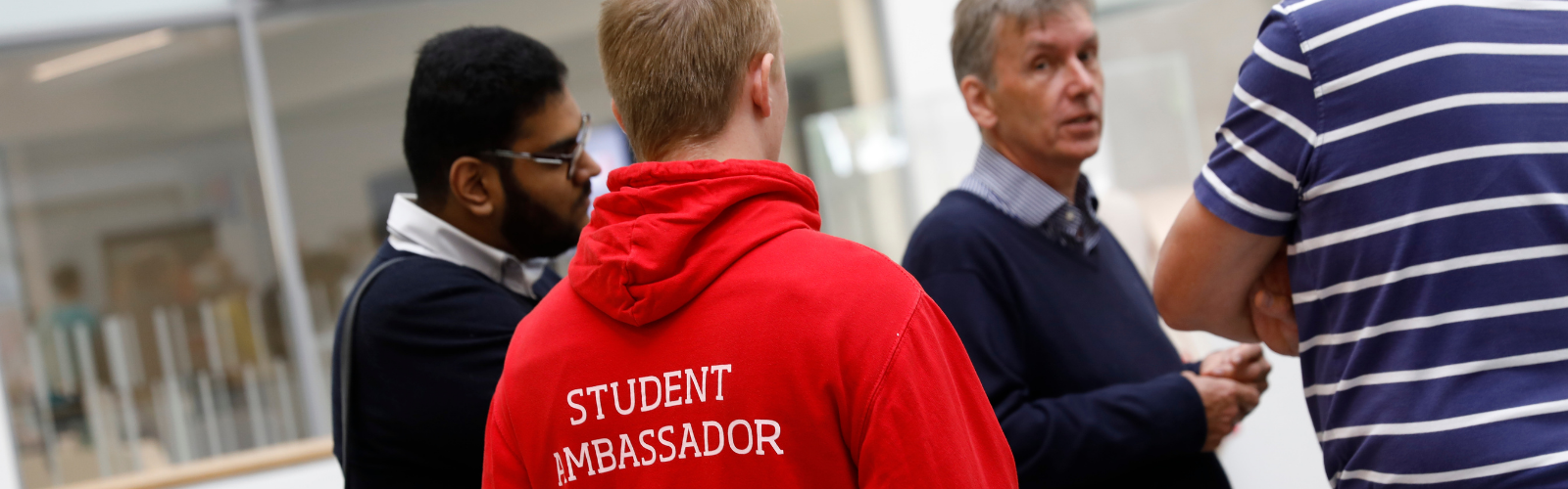 Photo from the back with the volunteer wearing the salford uni student red student ambassdor hoodie