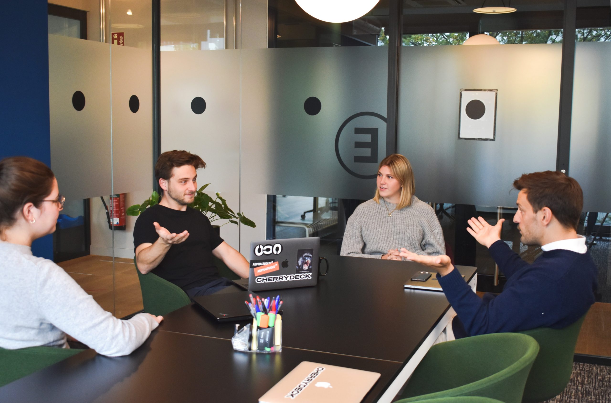 Four professionals sat around a table in a meeting