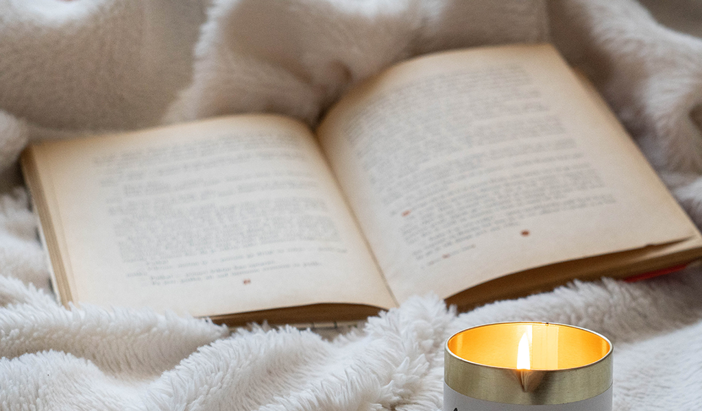 White and gold candle on top of a white cotton cloth