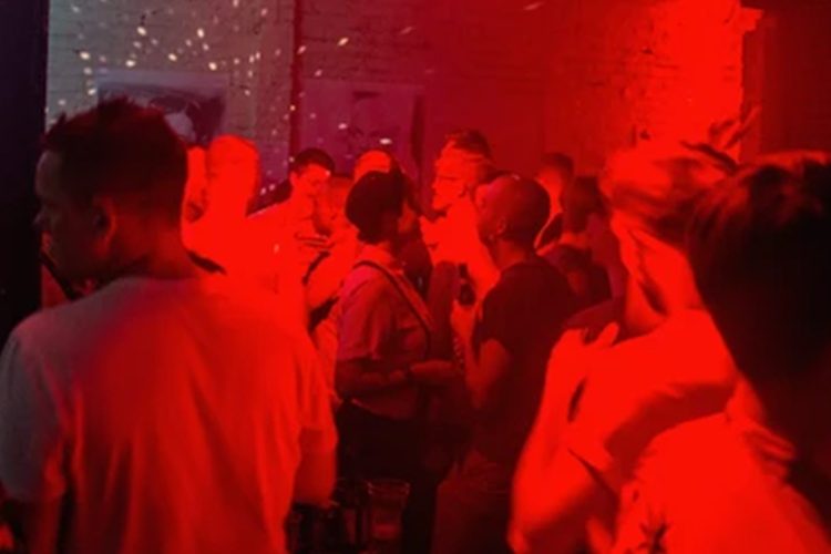 Photo of people inside a venue with red neon lighting