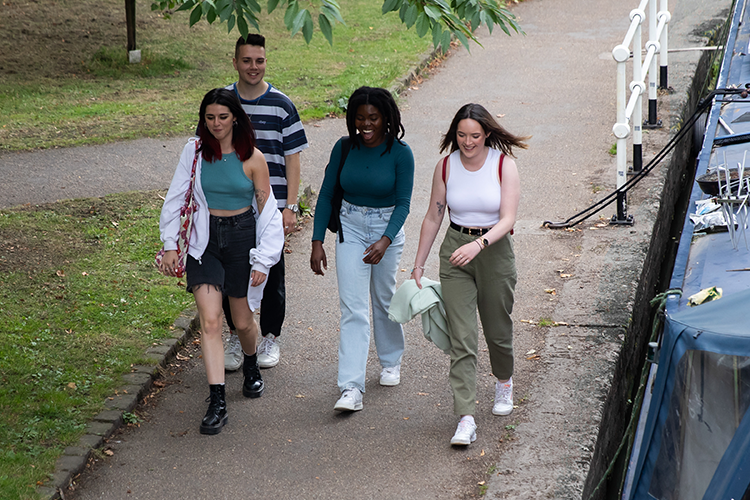 Photo of friends walking alongside water trail