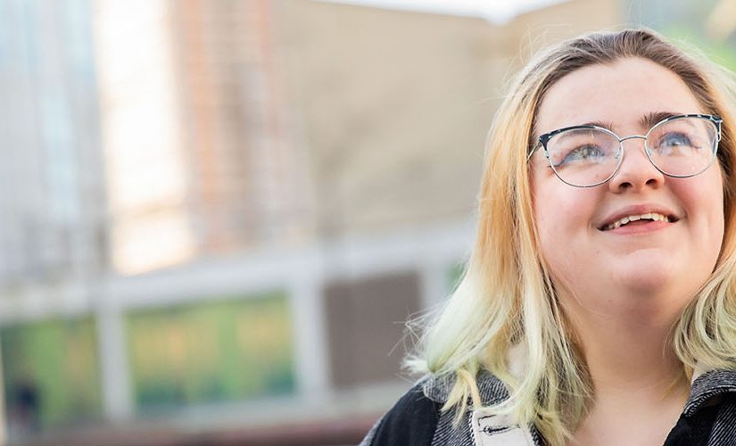 A photo of Ellie sat outside of Chapman Building