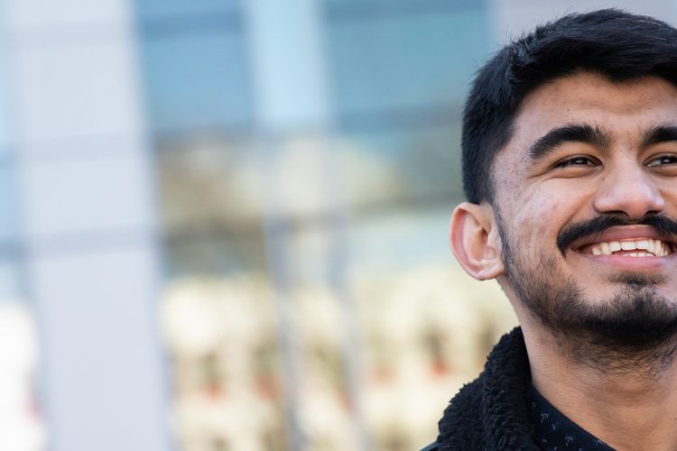 Photo of Sujan smiling outside the Chapman Building