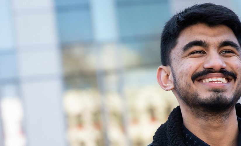 Photo of Sujan smiling outside the Chapman Building