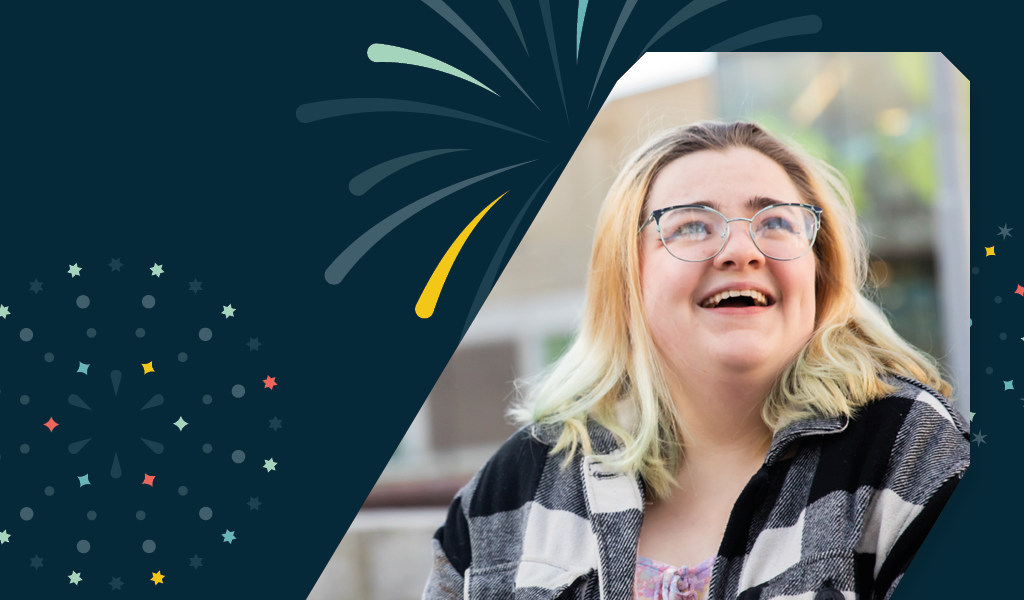 A photo of Ellie sat outside of Chapman Building against a background of illustrated fireworks