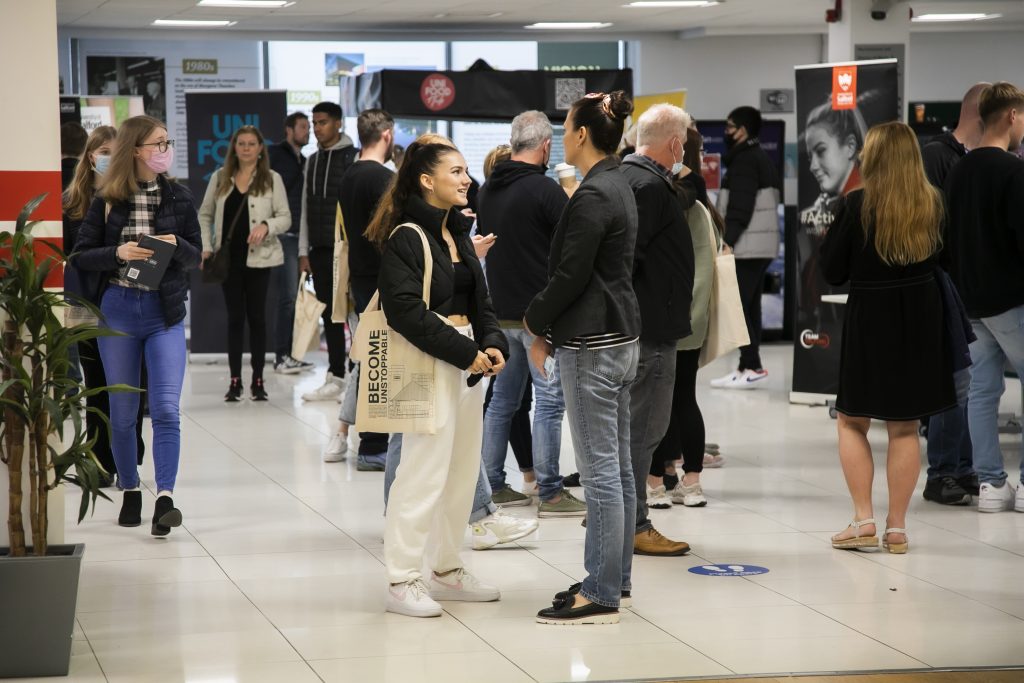 Photo of student wearing a black top talking to a guidance officer wearing a blazer