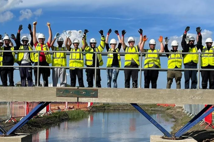 Students on a bridge at construction site at constructionarium