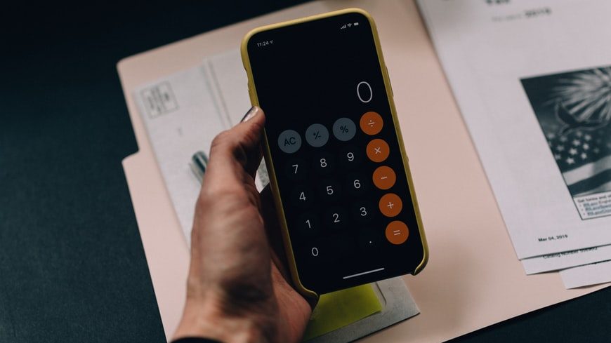 Student holding a phone with the calculator app open