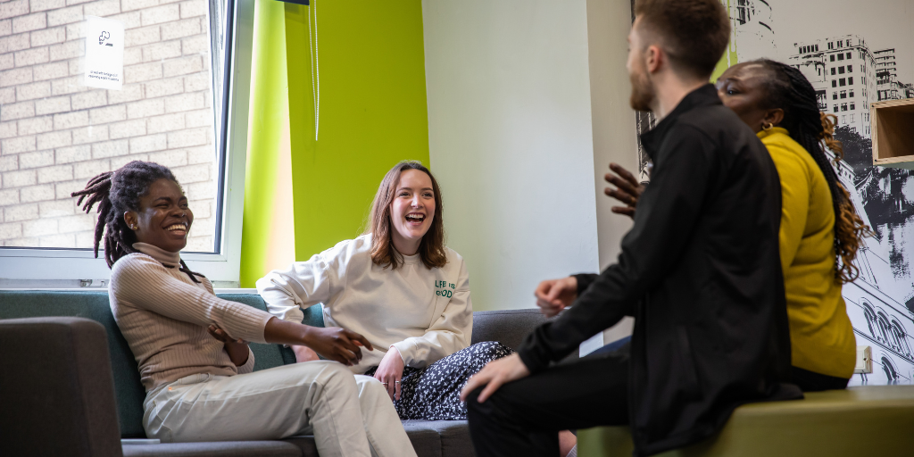 A group of four students laughing together