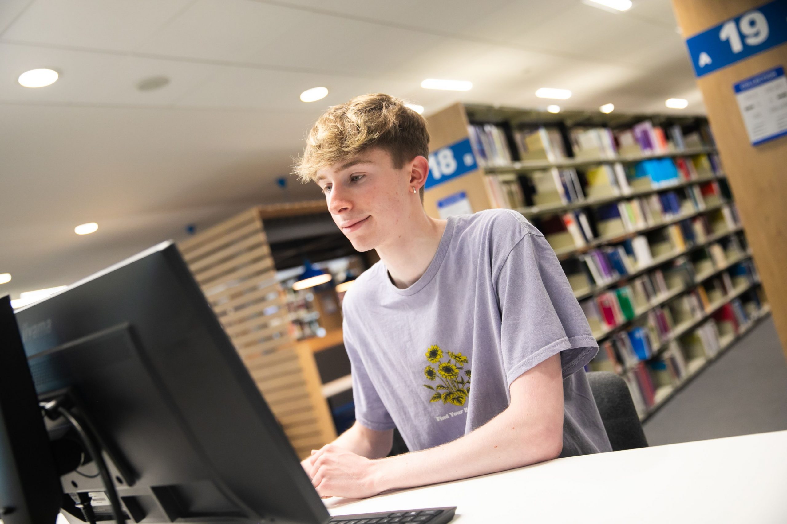 Student sat at a computer in the library